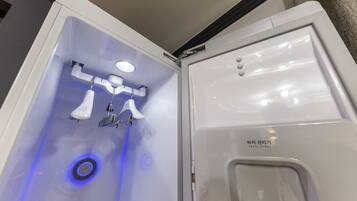 A bathroom with a white sink, a mirror, and a blue light.
