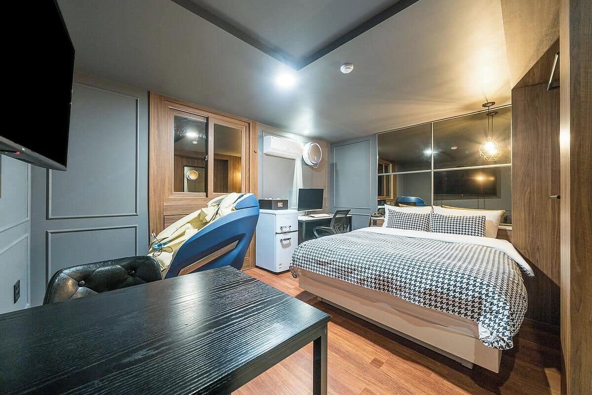 Un dormitorio con cama, escritorio, silla y armario.