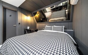 Ein Schlafzimmer mit einem großen Bett, einem Nachttisch, einem Spiegel und einer Tür.