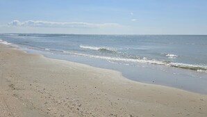 Una playa con cielo despejado y mar tranquilo.