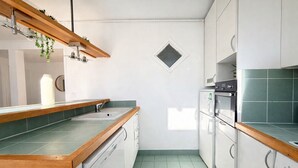 Een keuken met een houten aanrecht, een ingebouwde vaatwasser en een magnetron.