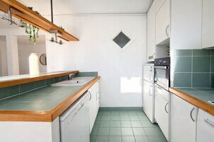 Una cocina con encimera de madera, lavavajillas integrado y microondas.