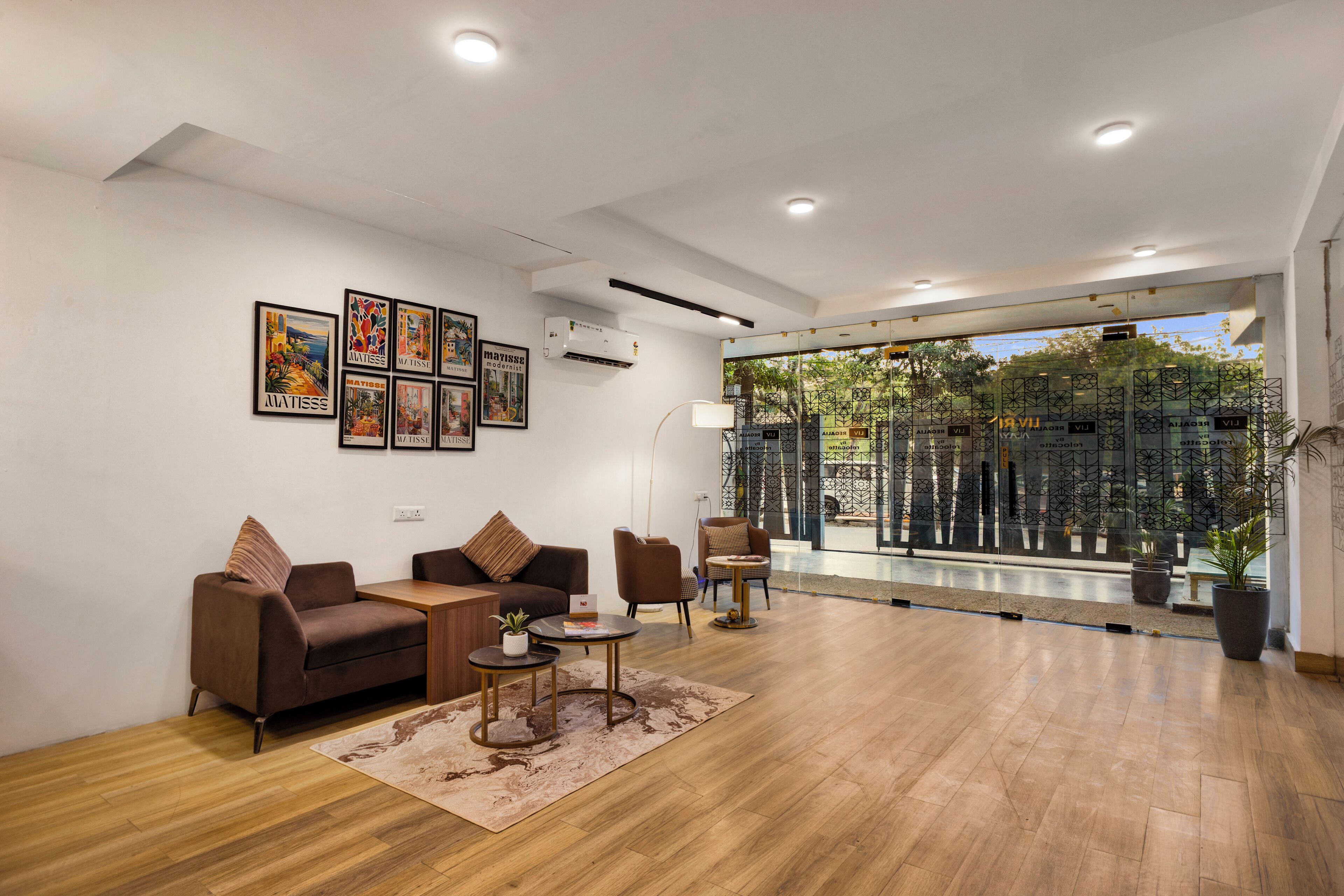 Una sala de estar moderna con un sofá, sillones, una mesa de centro y obras de arte en la pared.