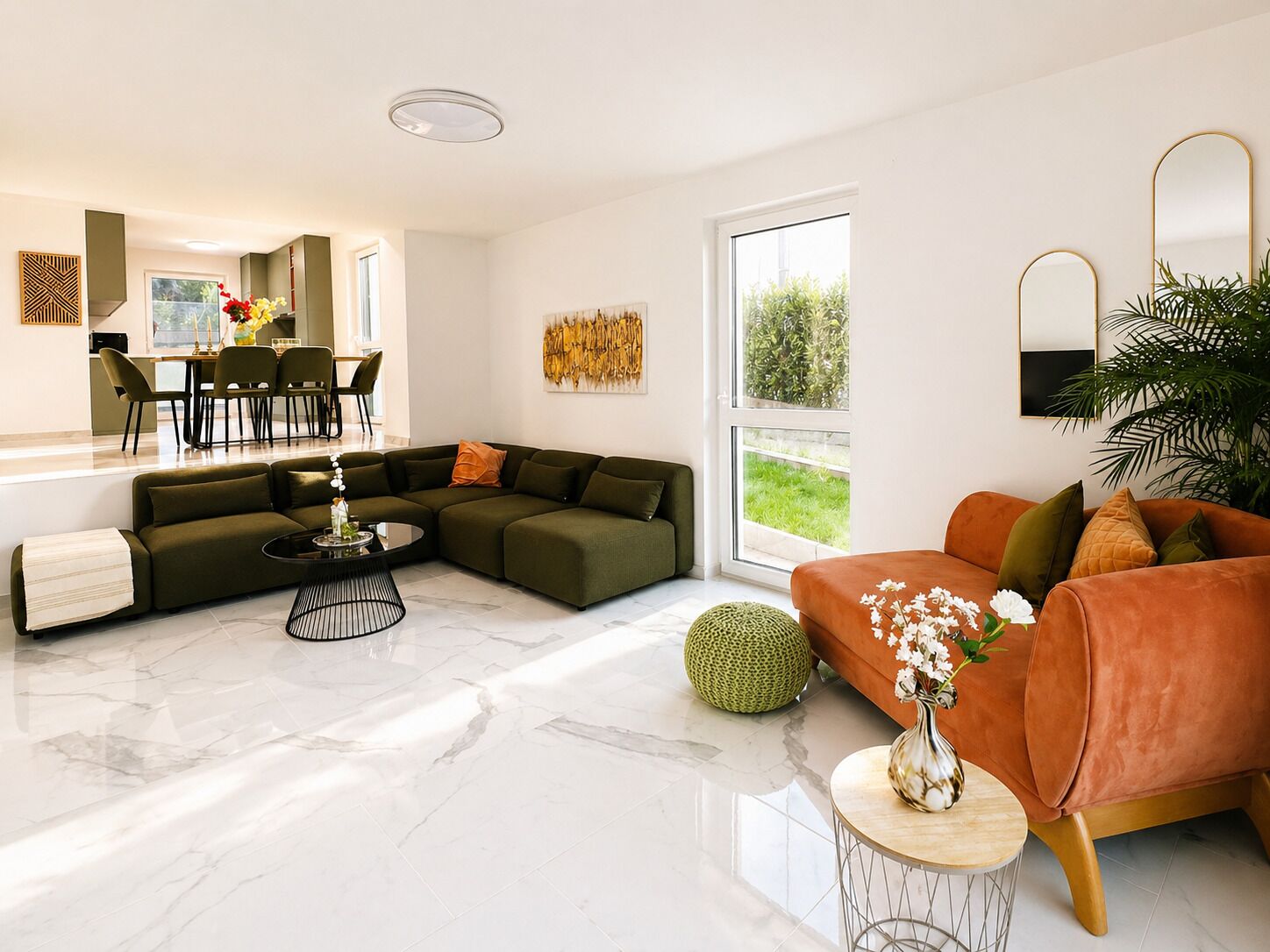 Een moderne woonkamer met een modulaire bank, een ronde salontafel en een eethoek met stoelen.