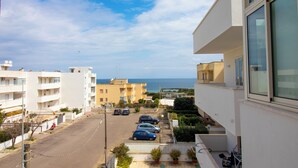 A residential area with a street, parked cars, and buildings. - Charming Holiday House With Ocean Views in Otranto (Otranto)