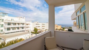A balcony with a view of the sea, white buildings, and a chair. - Charming Holiday House With Ocean Views in Otranto (Otranto)