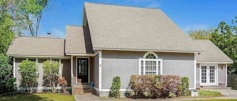 A single-story house with a front porch, a garage, and a small front yard.