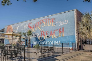 A mural of 'Surfside Beach' with outdoor seating and a fenced area. - A comfy stay close to the beach! Bike&Pet Friendly (Horry County)