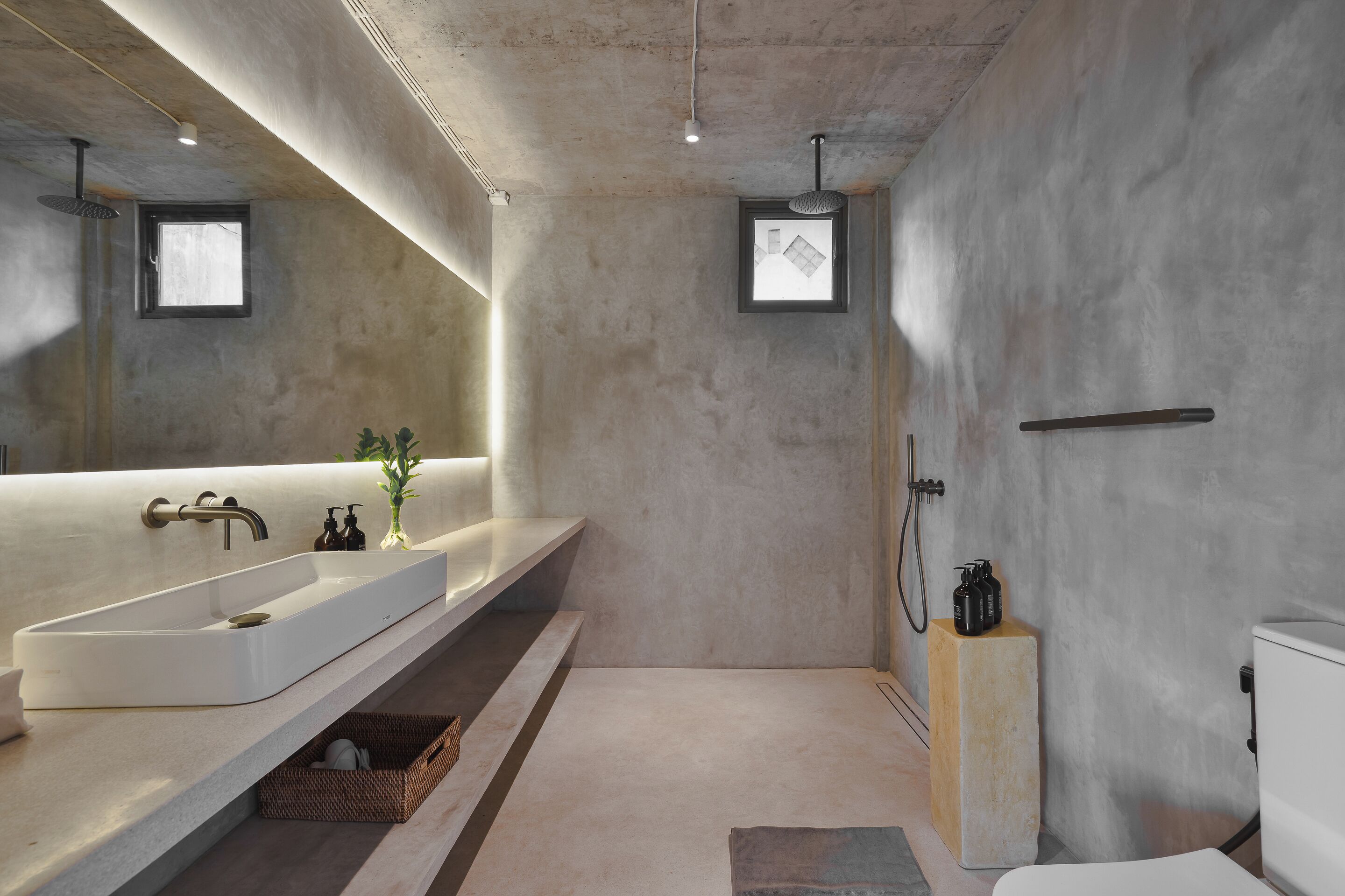 Un bagno moderno con uno specchio grande, due lavabi, una doccia e un water.