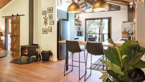 A modern kitchen with a central island, pendant lighting, and a large window.