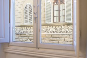 A window with white shutters and a decorative stone balustrade. - House Bardi Florence (Firenze)