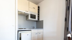 Eine kleine Küche mit Mikrowelle, Spüle und Kühlschrank.