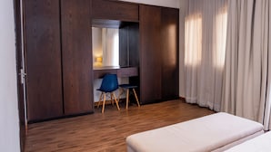 Ein Schlafzimmer mit Bett, Schreibtisch mit Stuhl und Kleiderschrank.