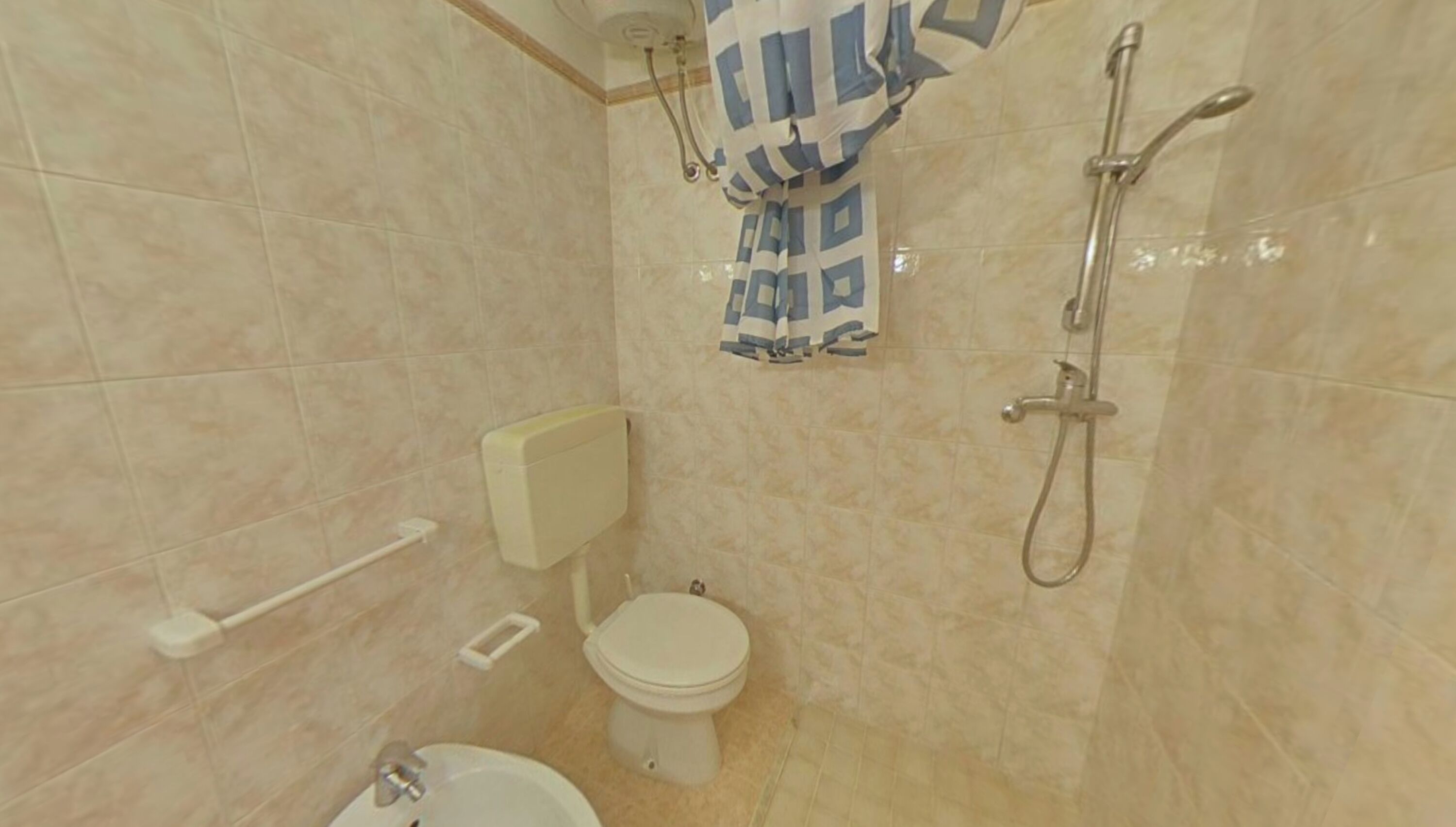 A bathroom with a toilet, bidet, and shower.