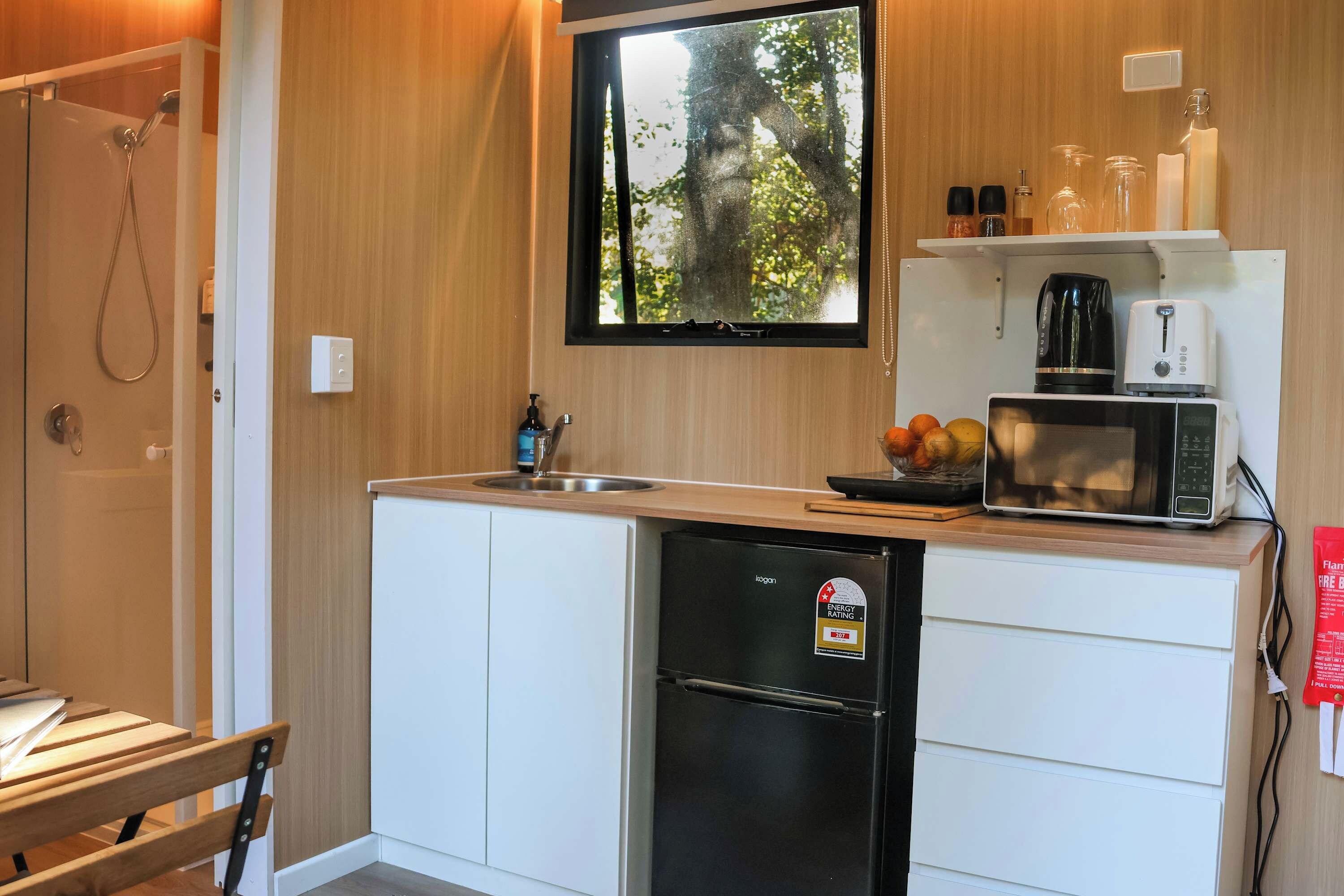 A compact kitchen with a built-in dishwasher, a microwave, and a coffee maker on the countertop.