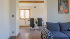 Um interior moderno com área de jantar, sofá e um quadro na parede.
