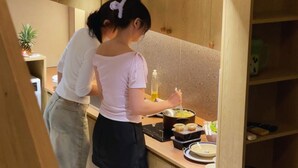 A kitchen with wooden cabinets, a countertop with food items, and a small plant.