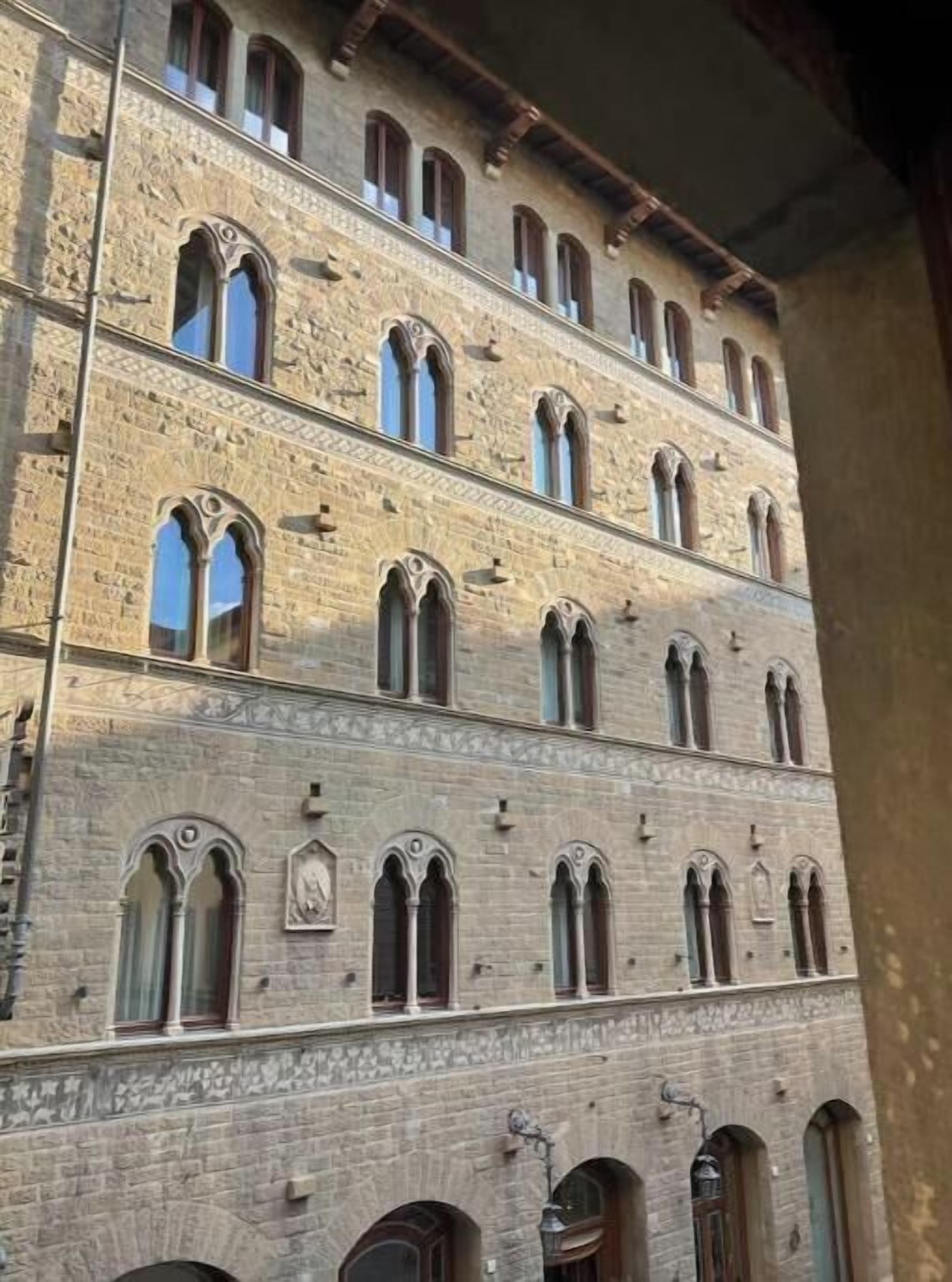 A multi-story building with arched windows and stone facade.