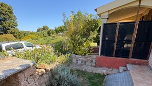 A stone patio with a metal grate, a stone wall, and a covered outdoor seating area. - Holiday Home 'Appartamento Baia 12' with Private Garden, Wi-Fi and Air Conditioning (Baia Vignola)