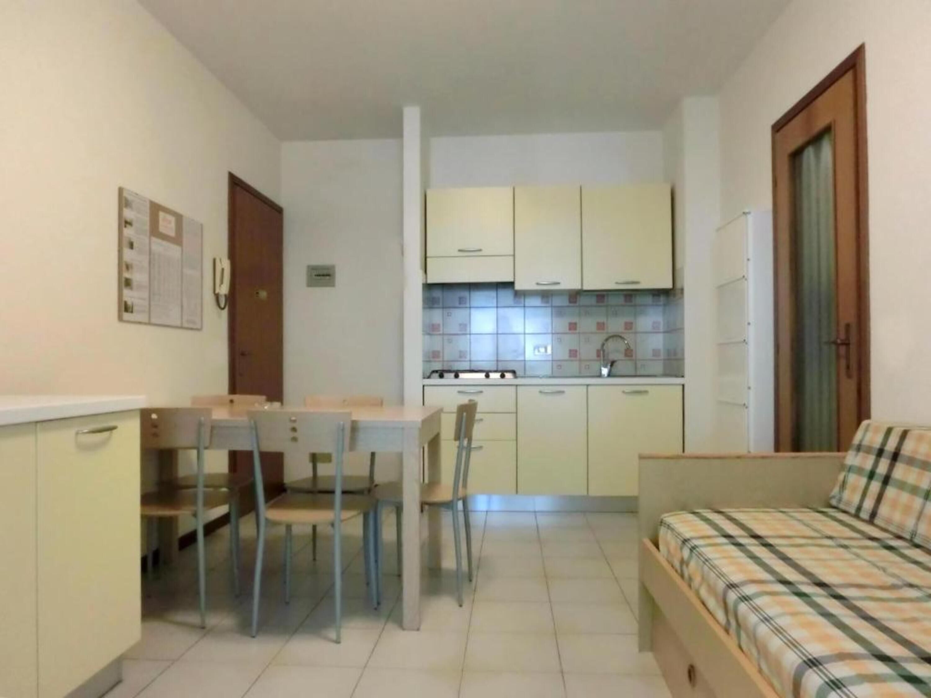 Uma cozinha compacta com área de refeições, uma cama e uma mesinha.