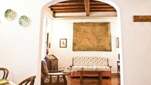 A room with a wooden ceiling, a sofa, a table, and a tapestry on the wall. - An authentic stay in the heart of Florence, a stone's throw from history (Firenze)