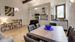 Une cuisine moderne avec un coin repas, un plancher en bois et une grande fenêtre.