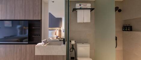 Un baño moderno con inodoro, lavamanos y espejo.