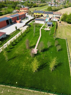 Vue aérienne d’un quartier résidentiel avec une pelouse bien entretenue, un chemin et plusieurs maisons équipées de panneaux solaires.