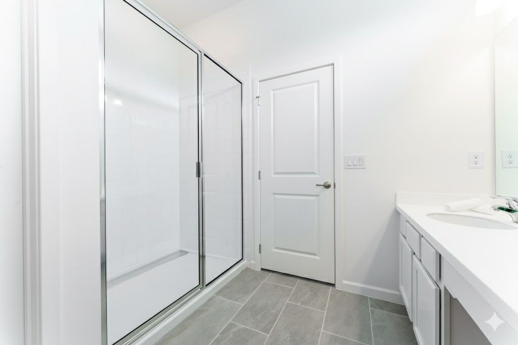 A bathroom with a shower, a toilet, and a sink.