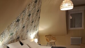 A bedroom with a bed, a chair, a lamp, and a ceiling light fixture.