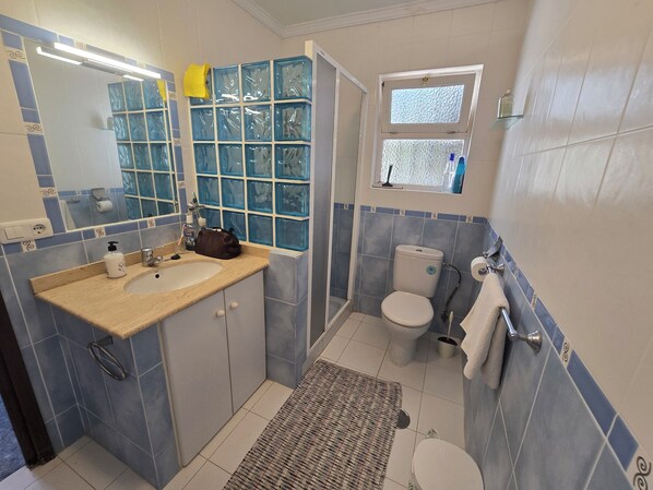 Un baño con lavamanos, inodoro y ventana.
