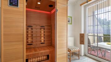 Eine Sauna mit Bedienfeld, Holzwänden und einer Sitzbank.