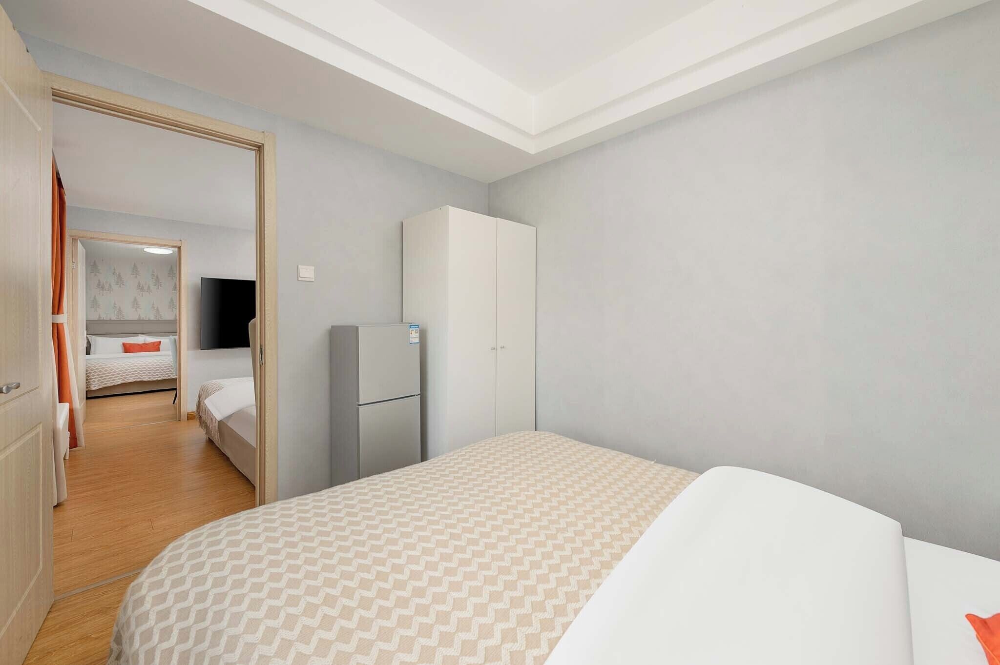 A hotel room with a bed, wardrobe, and a television in the corner.