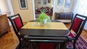 Un comedor con una mesa, sillas y una planta en maceta.
