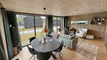 A modern interior with a dining area, sofa, and fireplace.