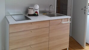 Una cocina moderna con estufa integrada, un lavamanos y un mueble con cajones.