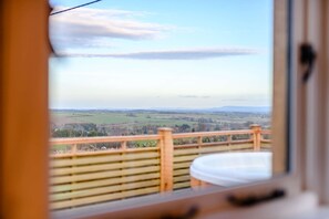 Ein Zimmer mit Blick auf eine ländliche Landschaft durch ein Fenster.