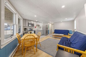 A compact living space with a dining area, kitchenette, and a sofa. - Ocean Air Suites 300 Feet from Beach, Strip (Hampton)