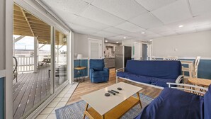 A modern living room with a sofa, a coffee table, and a balcony with a view. - Ocean Air Suites 300 Feet from Beach, Strip (Hampton)