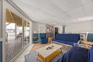 A modern living room with a sofa, a coffee table, and a balcony with a view. - Ocean Air Suites 300 Feet from Beach, Strip (Hampton)