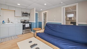 A compact living space with a kitchenette, a sofa, and a small table. - Ocean Air Suites 300 Feet from Beach, Strip (Hampton)
