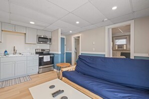 A compact living space with a kitchenette, a sofa, and a small table. - Ocean Air Suites 300 Feet from Beach, Strip (Hampton)