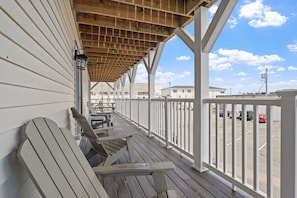 A wooden deck with benches, a railing, and a view of a parking lot. - Ocean Air Suites 300 Feet from Beach, Strip (Hampton)