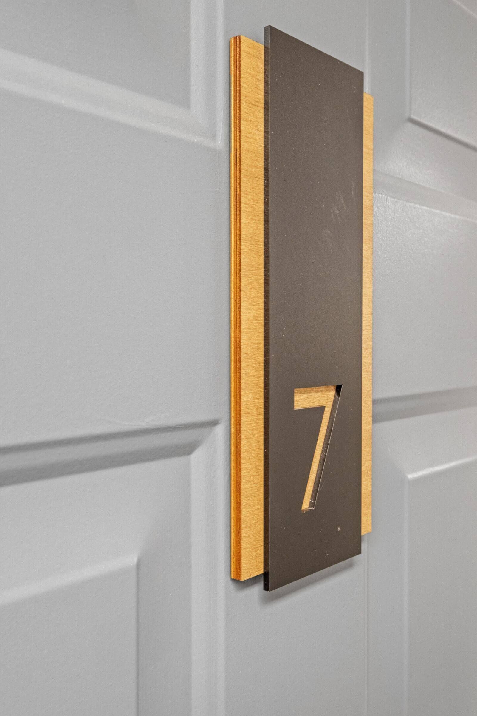 Une porte avec une plaque indiquant le numéro de la chambre : 7.