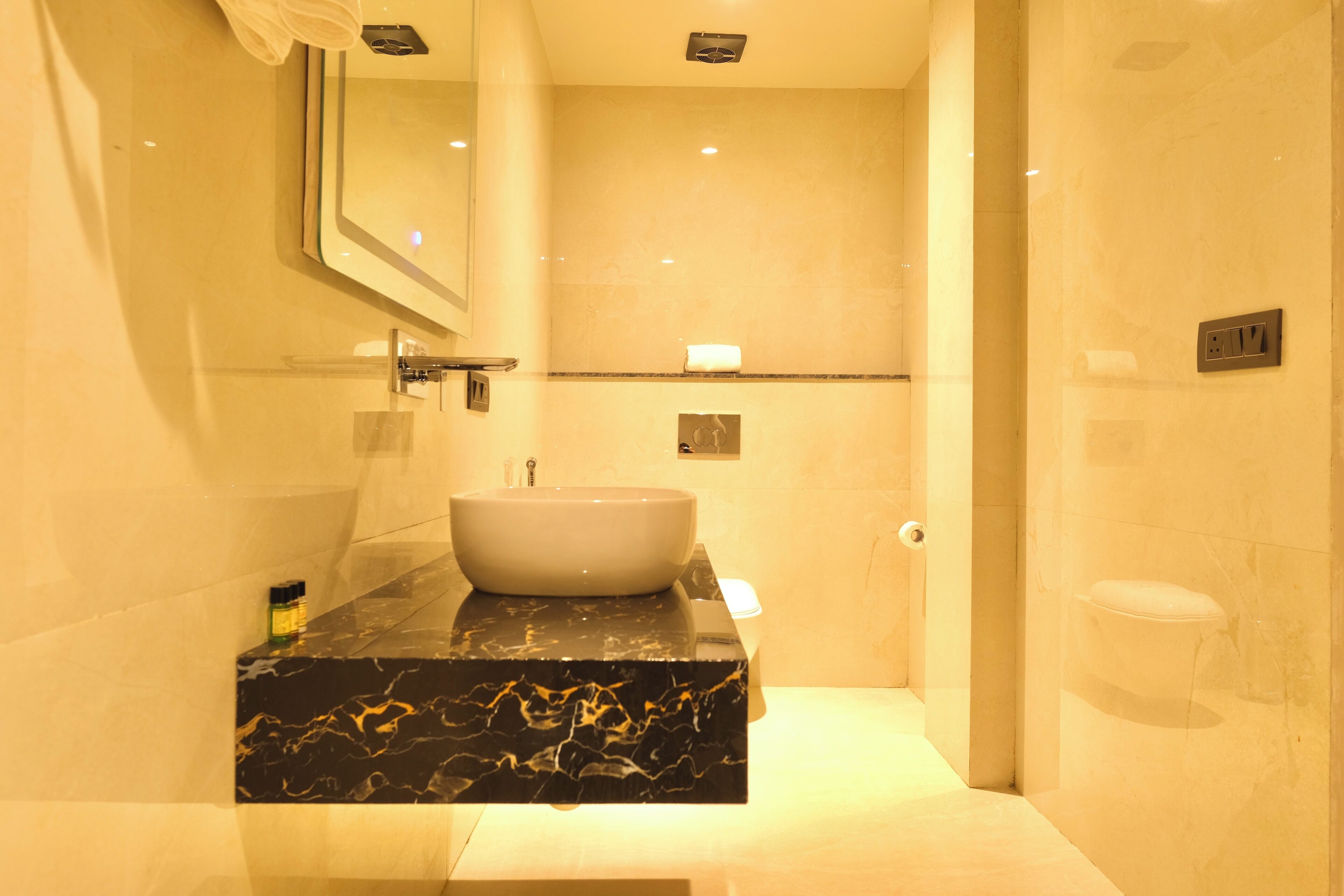 A bathroom with a marble sink, a mirror, and a towel rack.
