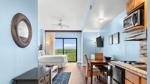 A bedroom with a bed, a dresser, and a view of the outdoors. - Origin 1115 | Cozy studio, steps to beach + free activities (Panama City Beach)