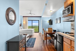 Ein Schlafzimmer mit Bett, Kommode und Blick ins Freie.