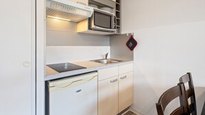 A compact kitchen with a microwave, stove, and sink. - Charming apart for 4 pers near shops (Grasse)
