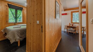 Een kamer met houten lambrisering, een bed, een bureau en een stoel.