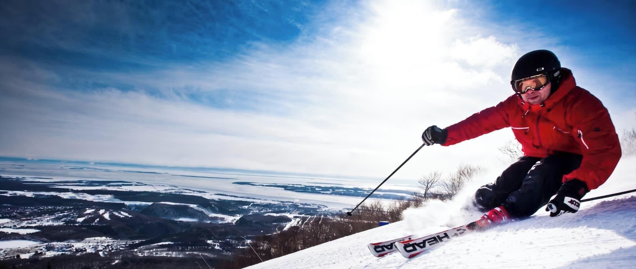 A person skiing on a snowy slope with a clear view of a valley below.